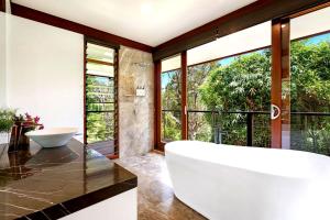 a bathroom with a large tub and large windows at Bodhi Nature in Coorabell Creek +35 photos
