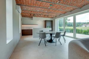 a kitchen and dining room with a table and chairs at Ferme de Pétrieux - Gîte "Le Peuplier" avec piscine et wellness in Tournai