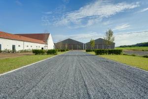 an empty road in front of a barn at Ferme de Pétrieux - Gîte "Le Peuplier" avec piscine et wellness in Tournai