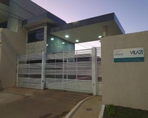 a house with a garage door with a sign on it at Canto da Árvore in Brasilia +2 photos