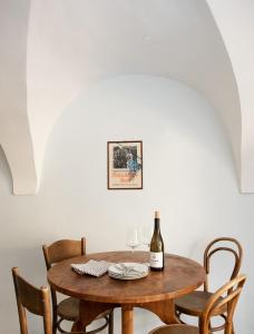 - une table en bois avec des chaises et une bouteille de vin dans l'établissement Fromm's Guesthouse, à Malans