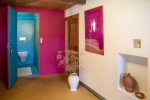 une salle de bain avec toilettes et un mur bleu et rose dans l'établissement Fromm's Guesthouse, à Malans