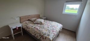 Un dormitorio pequeño con una cama y una ventana. en CHEZ GERALDINE GITES à LA FERME, en Muntzenheim