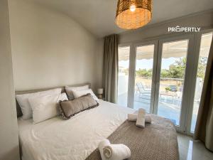 a bedroom with a large white bed with a balcony at Oasis by the Pool in Nea Kallikrateia +27 photos