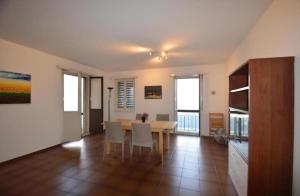 a dining room with a table and white chairs at Lake Lugano Cademario LakeView Apartment BEST SUNSET & SUNRISE in Ticino in Cademario