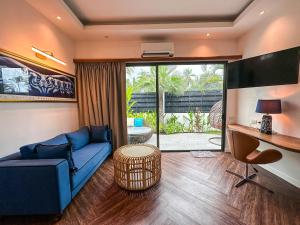 a living room with a blue couch and a desk at La Belle Vie - Boutique Hotel Adults Only in Baan Tai
