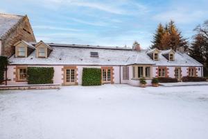 ein großes weißes Haus mit einer Auffahrt im Schnee in der Unterkunft Grieves Cottage Balnagown Estate in Kildary