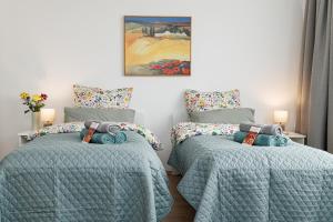 a bedroom with two beds and a painting on the wall at Apartment Flora gemütlich und zentral in Mönchengladbach in Mönchengladbach