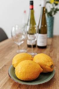 a plate of lemons on a table with wine glasses at Apartment Flora gemütlich und zentral in Mönchengladbach in Mönchengladbach +11 photos