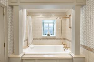 eine Badewanne im Bad mit Fenster in der Unterkunft Grieves Cottage Balnagown Estate in Kildary + 19 Fotos