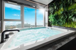 a jacuzzi tub in a bathroom with a large window at Quorum - Apartamenty z Widokiem na Odrę in Wrocław