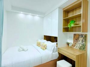 a white bedroom with a bed and a desk at Hotel tarzan in Amritsar
