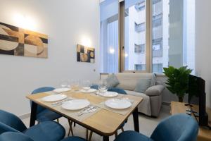 a dining room with a table and blue chairs at San Lázaro Suites in Granada