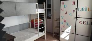 a room with a bunk bed next to a refrigerator at Sur les dunes in La Guérinière