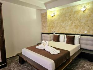 um quarto de hotel com uma cama com uma toalha em Pensiunea Ghiocela em Motru mais 10 fotografias