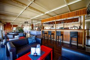 a restaurant with couches and a bar at Botel Marina in Rijeka