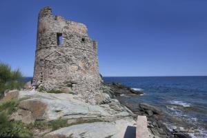 an old stone tower on the shore of the ocean at Casa Torra d'Erbalunga in Brando