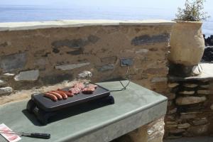 a grill with hot dogs and donuts on top of a wall at Casa Torra d'Erbalunga in Brando
