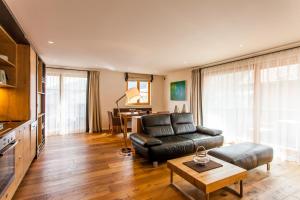 Una sala de estar con un sofá de cuero y una mesa. en Dorfhaus Chalets, en Oberstaufen
