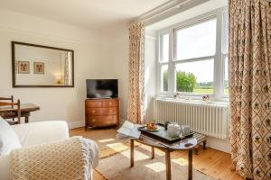 a living room with a bed and a window at Lodge Farm Cottage in Sudbourne