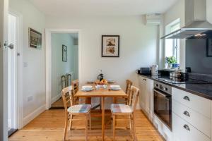 a kitchen with a wooden table and chairs in a kitchen at Lodge Farm Cottage in Sudbourne