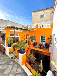 an orange building with potted plants on the balcony at Casa 3 Apartment and Artist Residence in Polopos +34 photos