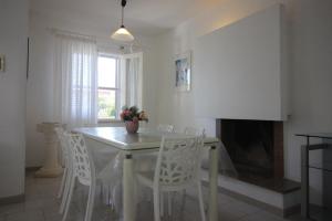 Un comedor con mesa y sillas y chimenea. en Villa Melpignano, en Torre Santa Sabina 27 fotos más