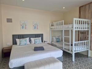 a bedroom with two bunk beds and a white bed at STAYHERE@AIRPORT SERVICE APARTMENT in Ban Bo Han