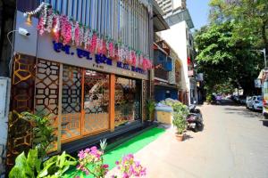 una tienda en una calle con flores en la acera en N M Hotel Nr kokilaben Hospital, en Bombay