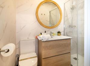 un baño con inodoro y espejo en Charming Seaside Apartment in Barceloneta, Renovated with Stunning Sea Views, en Barcelona