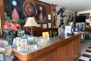 a woman sitting at a reception counter in a store at The Nice Patong Hotel in Ban Nong Chaeng +54 photos