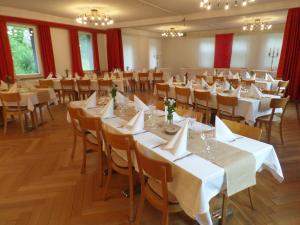 um salão de banquetes com mesas e cadeiras brancas em Hotel Rigi Klösterli em Kulm