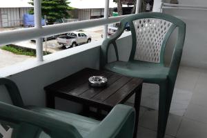 a green chair and a table on a balcony at The Nice Patong Hotel in Patong Beach