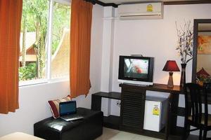 a living room with a television and a chair at The Nice Patong Hotel in Patong Beach +37 photos