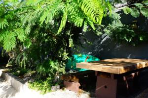 un banco de madera sentado frente a un árbol en Apartments Sunny, en Karlobag