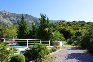 una piscina con una valla y montañas en el fondo en Apartments Sunny, en Karlobag