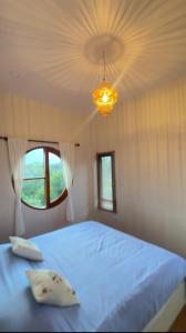 a bedroom with a large bed and a chandelier at ม่อนหมอกเชียงดาว in Chiang Dao