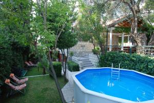 un patio trasero con bañera de hidromasaje y un árbol en Holiday Home Olive Tree en Budva