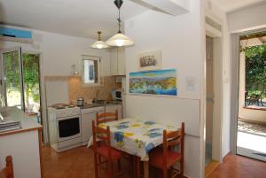 a kitchen with a table and a table and chairs at Holiday Home Olive Tree in Budva