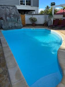 a swimming pool with blue water in a house at Chez Arlette in Saint-Louis +9 photos