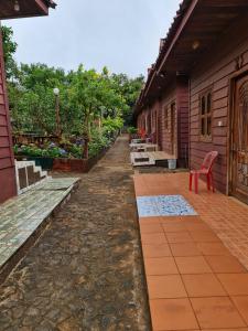 Un patio con una silla roja al lado de un edificio. en Phanyro Motel, en Krong Saen Monourom
