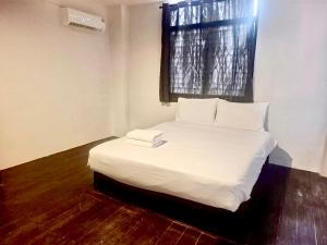 a white bed in a room with a window at Mitr Inn Khaosan Road - มิตร อินน์ ถนนข้าวสาร Pro in Bangkok