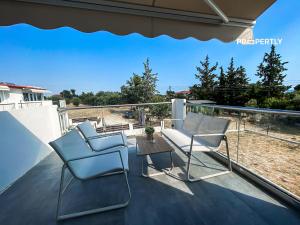 two chairs and a table on a balcony at Oasis by the Pool in Nea Kallikrateia