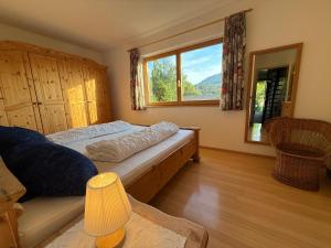 a bedroom with a bed and a large window at Landhaus Margarete im Feriendorf Reichenbach in Nesselwang
