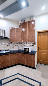 a kitchen with wooden cabinets and a counter top at Star Guest House in Jhelum
