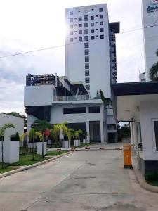 a large white building with a parking lot in front at Davao Condo Bed Space - Safe, Affordable & Comfy in Davao City