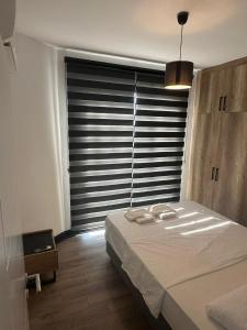 Un dormitorio con una cama y una ventana con persianas. en Mila Marina, en Kyrenia