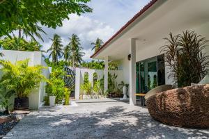 a house with a courtyard with plants at La Belle Vie - Boutique Hotel Adults Only in Baan Tai