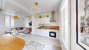 a kitchen and living room with a table and a couch at Maison moderne au calme,coeur de ville-3 chambres 2 sdb in Sens