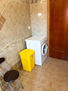 a washing machine and a yellow trash can in a bathroom at Perla sul Mare in Vibo Valentia Marina
